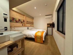 a bathroom with a bed and a sink in a room at Besso城前 in Himeji