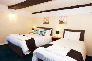 A bed or beds in a room at The Black Swan Inn