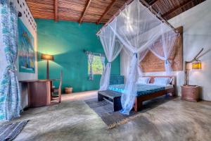 a bedroom with a bed with a mosquito net at Villa Lokobe in Hell-Ville