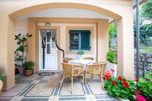 a patio with a table and chairs and flowers at Jadran Apartments in Rafailovici