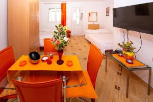a small room with a table and a room with a bed at Jadran Apartments in Rafailovici