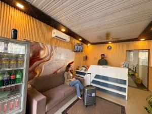 a woman sitting on a couch in a store at Hotel Mahadev Tapovan in Rishīkesh