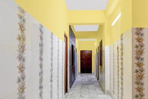 a hallway with yellow walls and a red door at Super Hotel O Chittaranjan Railway Station Formerly Khalsa Lodge in Āsansol