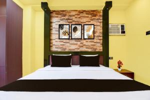 a bedroom with a bed and a brick wall at Super Hotel O Chittaranjan Railway Station Formerly Khalsa Lodge in Āsansol +24 photos