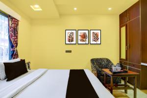 a hotel room with a bed and a chair at Super Hotel O Chittaranjan Railway Station Formerly Khalsa Lodge in Āsansol