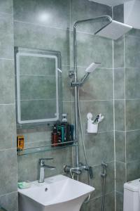 a bathroom with a sink and a shower with a mirror at Auri House in Hanoi +4 photos
