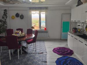 a kitchen with a table and chairs and a dining room at Oskon Guesthouse in Kyzart
