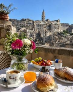 a table with breakfast food and a view of a city at Il Geco in Matera