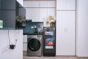 a kitchen with a refrigerator and a washing machine at Auri House in Hanoi