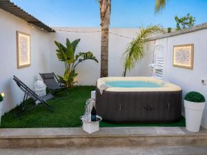 a hot tub in a yard with a chair at Alicam in Uggiano la Chiesa