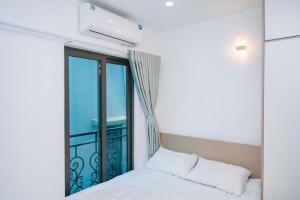a bedroom with a bed and a large window at Auri House in Hanoi