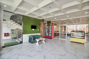 a large lobby with a couch and a table at Treebo Chanakya Palm in Chhatikara