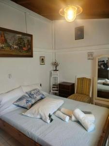a bedroom with a bed with pillows and a chair at Casa MUSA in Keratea