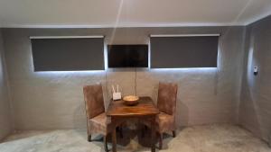 a table and chairs in a room with a wall at GROOTVALLEI SELF CATERING Units in Mahikeng