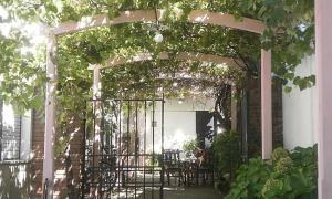 an arbor with tables and chairs on a patio at La Casa de Teresa in Colonia del Sacramento