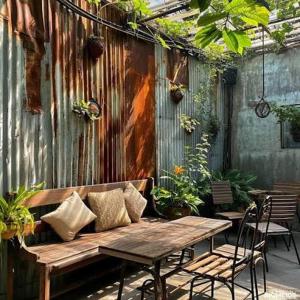 a patio with a wooden bench and a table and chairs at Vangvieng dream house in Vang Vieng