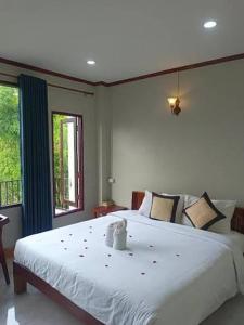 a bedroom with a large white bed and a window at Vangvieng dream house in Vang Vieng +38 photos