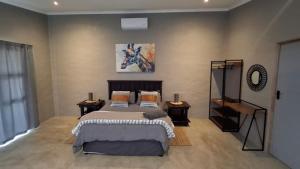a bedroom with a large bed and two night stands at GROOTVALLEI SELF CATERING Units in Mahikeng