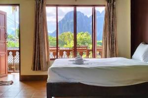 a bedroom with a bed and a large window at Vangvieng dream house in Vang Vieng