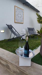 a bottle of wine and two glasses on a table at Alicam in Uggiano la Chiesa