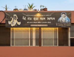 a sign on the side of a building at Shri Ved Vrinda Dham Aashram in Chhatikara