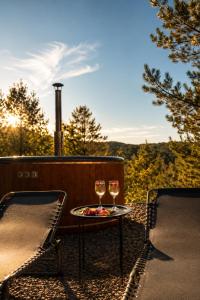 two glasses of wine sitting on a table on a porch at Nice House in Maidan Village