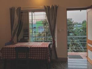 a room with a table and a large window at BrightMoon_Homestay in Pondicherry
