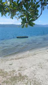 a boat sitting in the water on a beach at Kings guest house in Tuktuk Siadong +2 photos