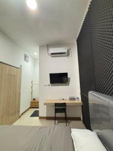 a room with a bed and a desk and a tv at Lovisya Residence in Jakarta