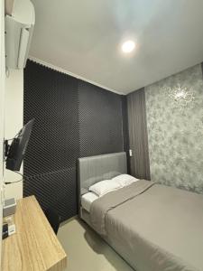 a bedroom with a bed and a desk with a computer at Lovisya Residence in Jakarta