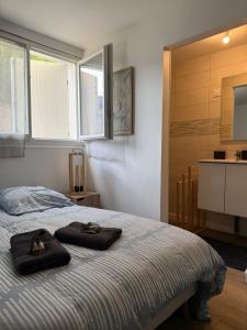 a bedroom with a bed with two towels on it at Charmant Studio privé en maison in Villenave-dʼOrnon
