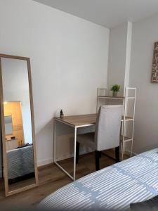a bedroom with a desk and a mirror and a bed at Charmant Studio privé en maison in Villenave-dʼOrnon