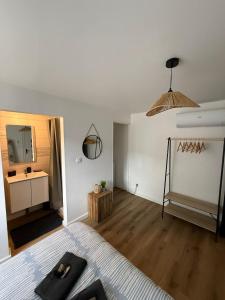 a white room with a bed and a bathroom at Charmant Studio privé en maison in Villenave-dʼOrnon