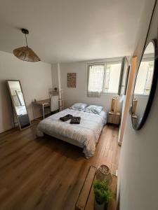 a bedroom with a bed and a wooden floor at Charmant Studio privé en maison in Villenave-dʼOrnon +1 photo
