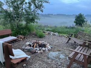 a firepit with two benches and a fire pit at Prosinko 25 in Prosinko