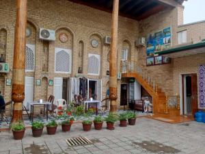 a building with a bunch of potted plants in front of it at Sohibqiron boutique in Bukhara