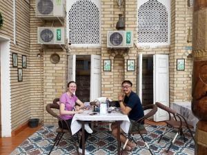 a man and a woman sitting at a table at Sohibqiron boutique in Bukhara