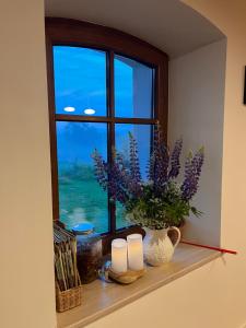 a window with candles and flowers on a shelf at Prosinko 25 in Prosinko
