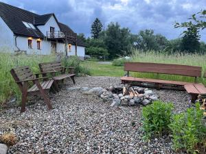 two benches and a fire place in front of a house at Prosinko 25 in Prosinko