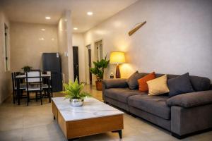 ein Wohnzimmer mit Sofa und Tisch in der Unterkunft Sunset Villas in Korotogo