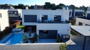 an aerial view of a white house with a swimming pool at Luxury Villa Meerbrise - Private Pool - Near Medulin, Kamenjak, Pola in Banjole