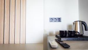 a table with two remote controls and a coffee maker at Costa Mare Rooms in Paralia Katerinis