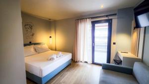a bedroom with a bed and a large window at Costa Mare Rooms in Paralia Katerinis