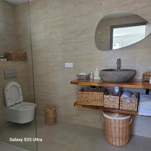 ein Badezimmer mit Waschbecken, Toilette und Spiegel in der Unterkunft Chez philo in Alata + 7 Fotos