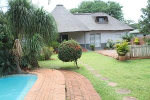a house with a pool in front of a yard at One love suites in Mokopane