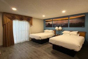 a hotel room with two beds and a window at Days Inn by Wyndham Medford in Medford