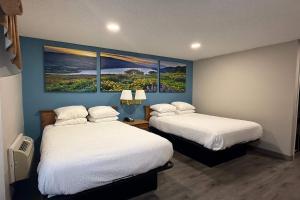 a room with two beds and two paintings on the wall at Days Inn by Wyndham Medford in Medford +24 photos