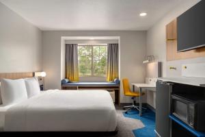 a hotel room with a bed and a desk and a window at Microtel Inn & Suites by Wyndham Culpeper in Culpeper +51 photos
