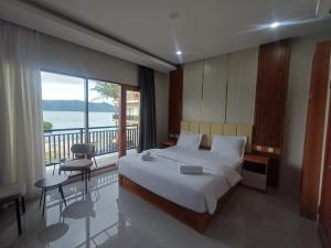 a bedroom with a large bed and a balcony at Lekjon Cottage in Tuktuk Siadong