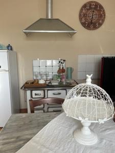 a kitchen with a table with a clock on the wall at Rosa'villa 5 in Murazzano